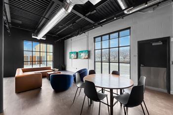 A room with a table, chairs and a painting on the wall.at Plant 1 Lofts, Iowa   